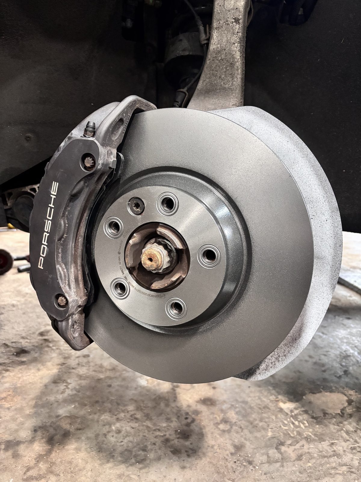 A new brake disc fitted behind a Porsche brake caliper