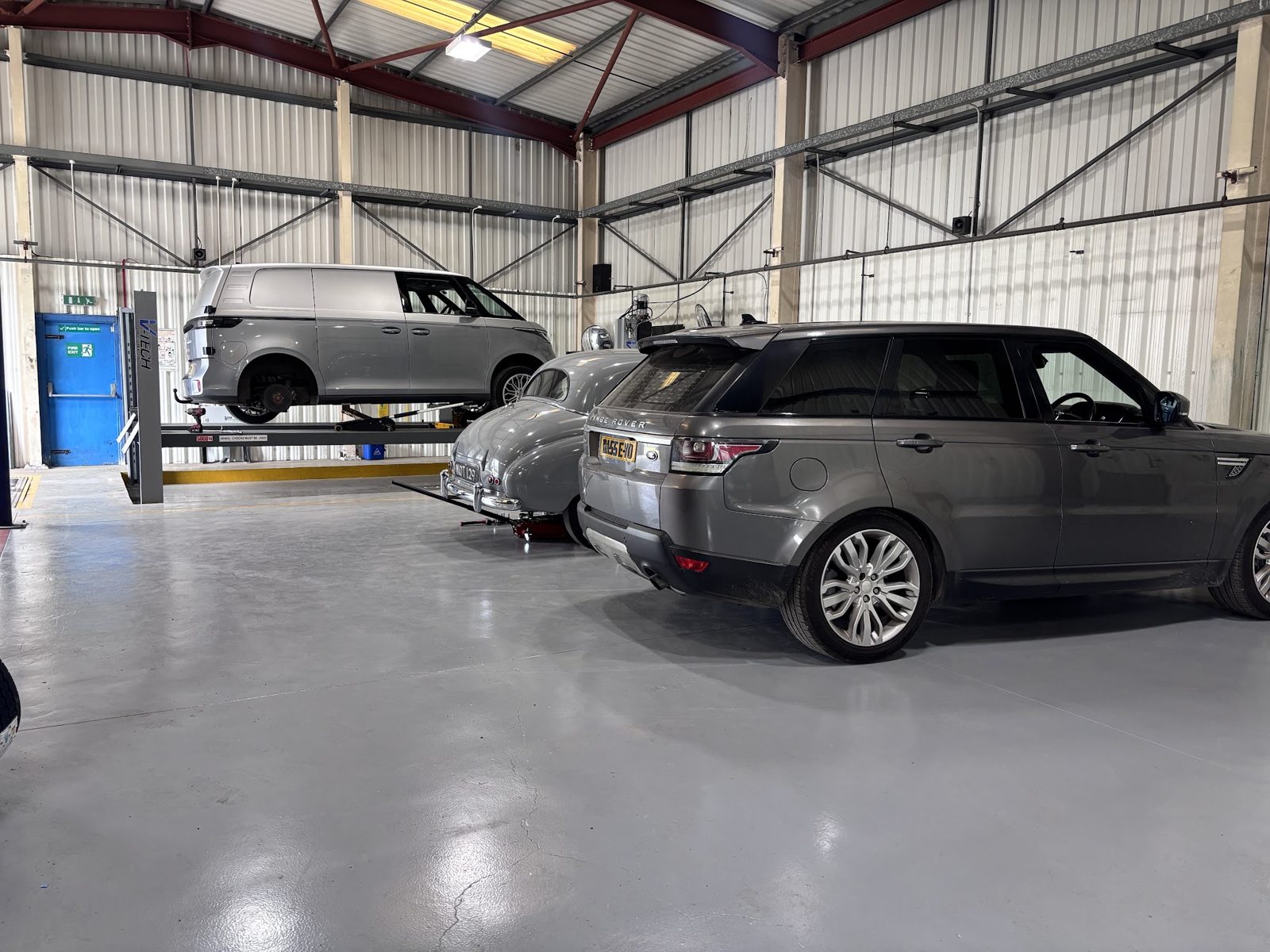 Inside the Woolston Motors workshop, a Range Rover on the floor and a van up on the lift