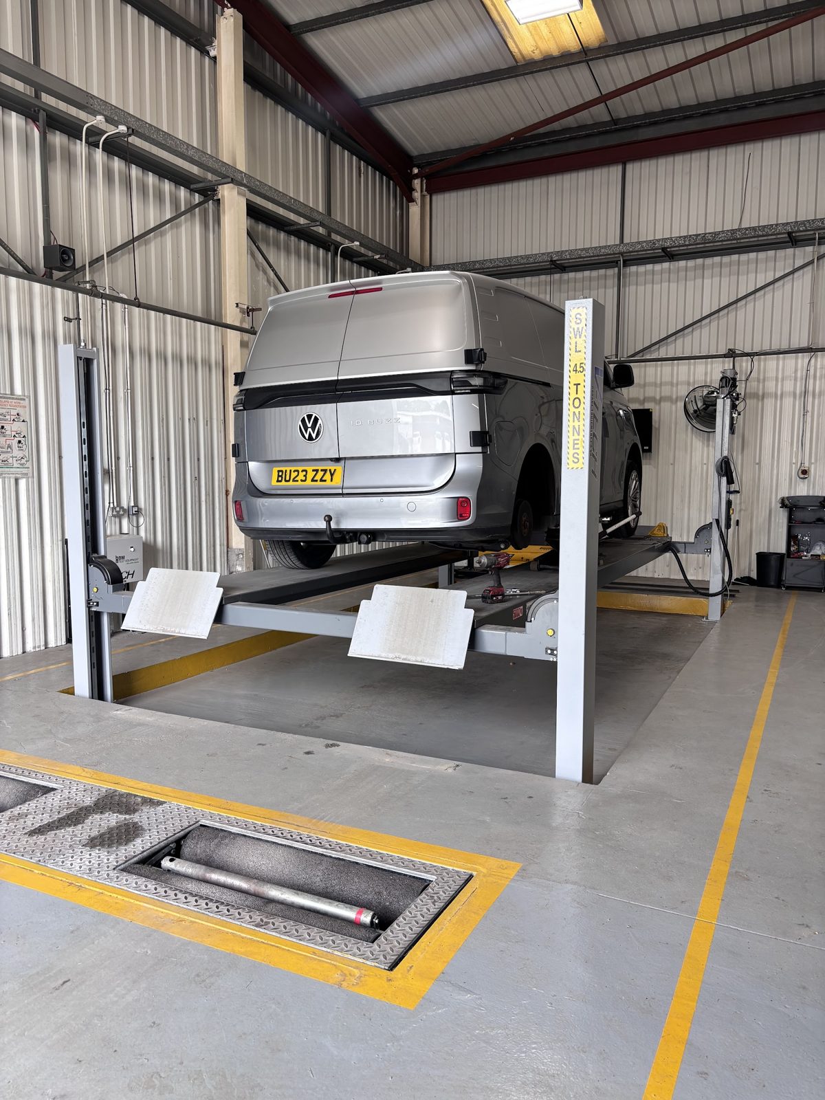 A Volkswagen van raised on the four-post lift in the Woolston Motors workshop