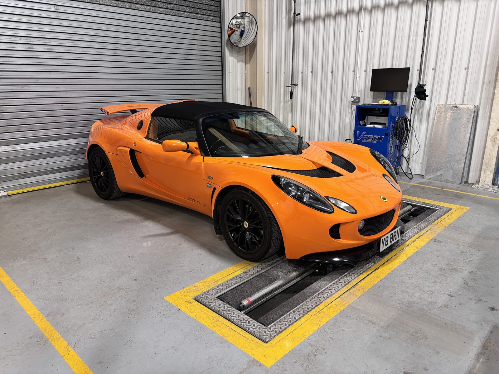 An orange Lotus Elise on the test bay at Woolston Motors